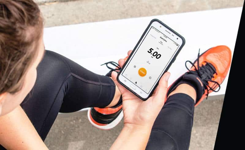 Woman sitting on the fllor and holding her smartphone