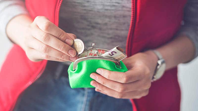 20 Different Money Saving Challenges Stay-At-Home Moms Can Try6woman putting coins in wallet