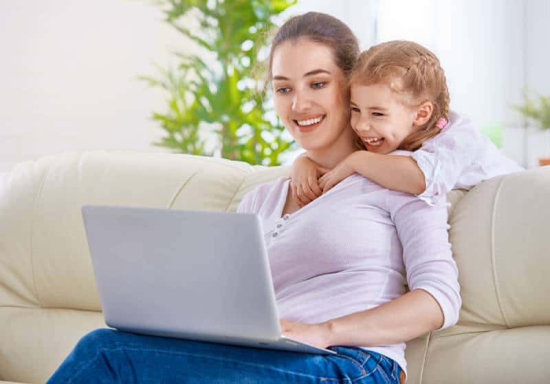happy mother and child looking ant laptop screen