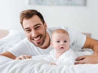 Dad with his baby on bed