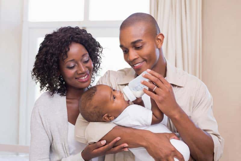 parents donnant un biberon à leur petit garçon