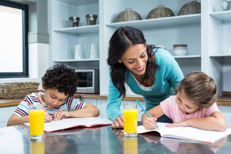 Satisfied children doing homework in the kitchen