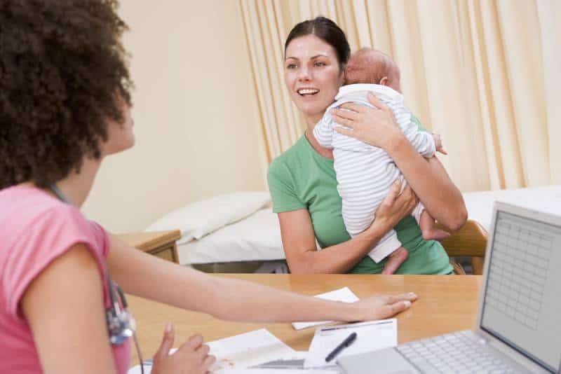 woman in doctor's office holding baby