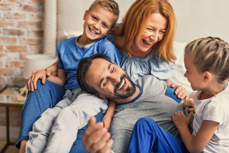 Happy family lying down on bed and smiling at home