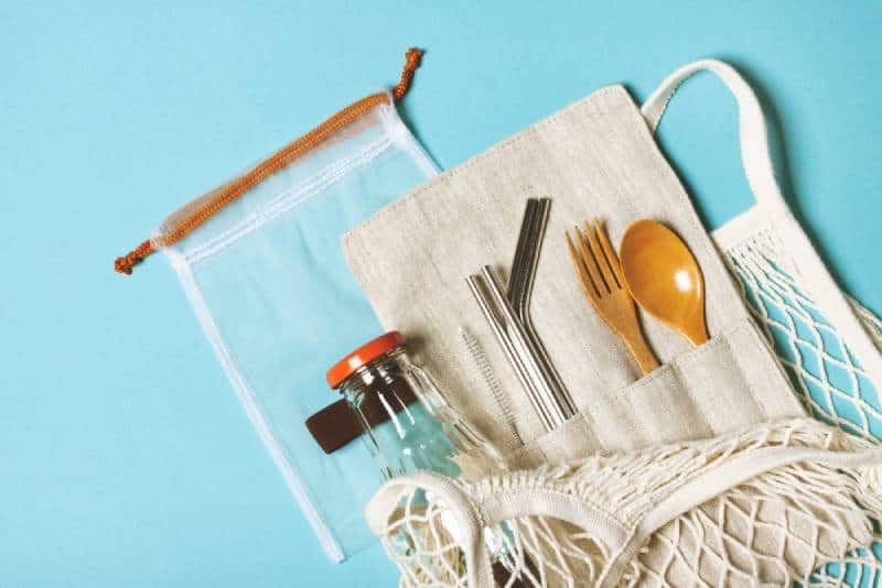 Reusable items - Eco bag, glass bottle for water, metal tubes, wooden fork and spoon 