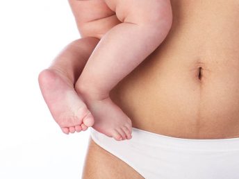 Woman holding baby wtih Postpartum Body
