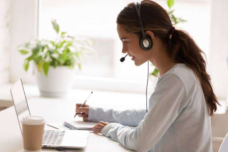 Woman wearing headset at her home and teaching online