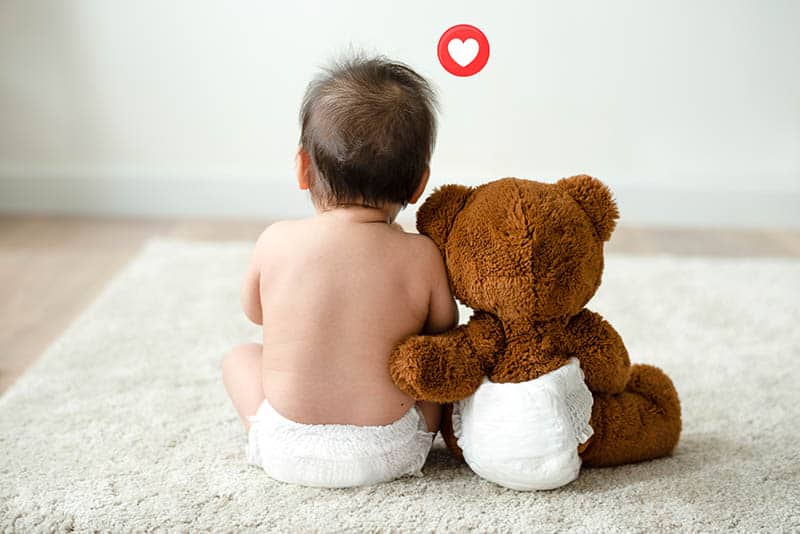 cute baby and teddy bear in diapers