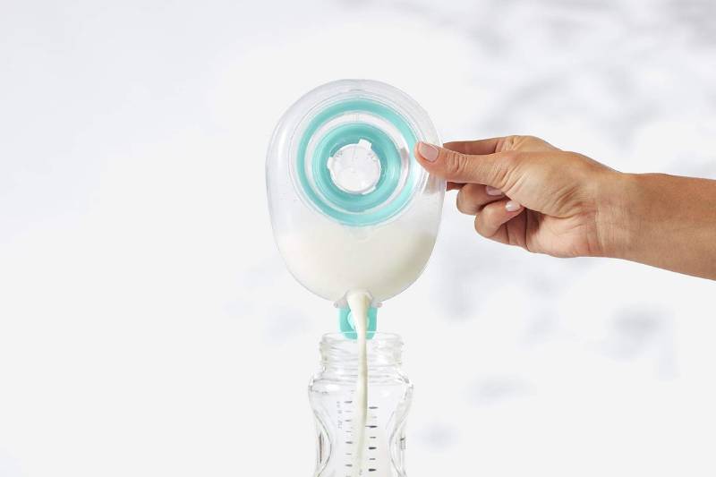 Woman's hand is poring milk into a milk container