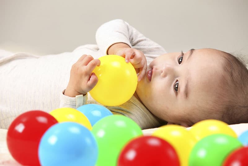 baby playing with colorful balls