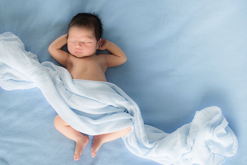 little baby boy sleeping on the bed