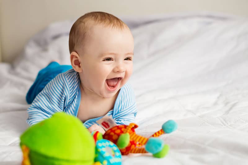 little baby smiling on the bed