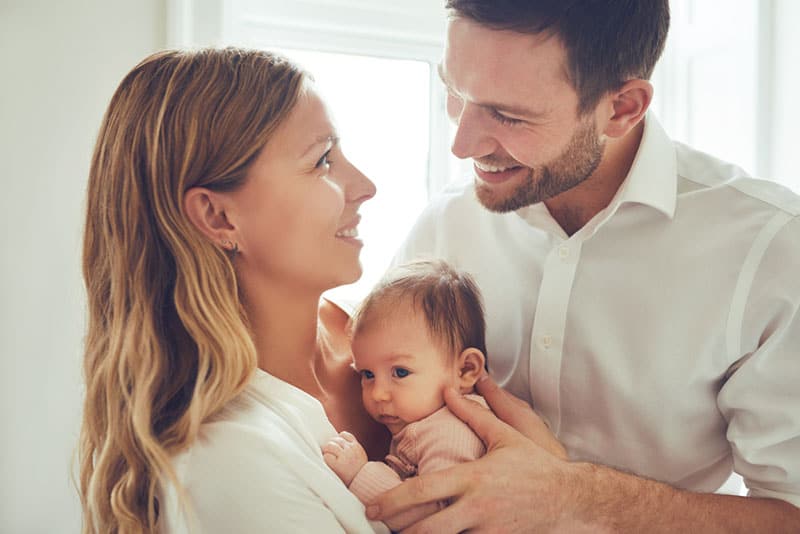 young parents standing with their baby