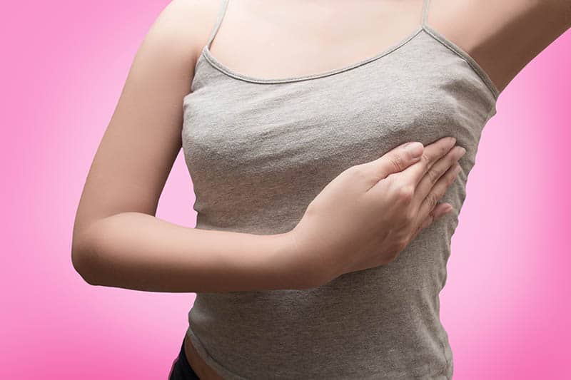 woman pressing her hand on her left painful breast