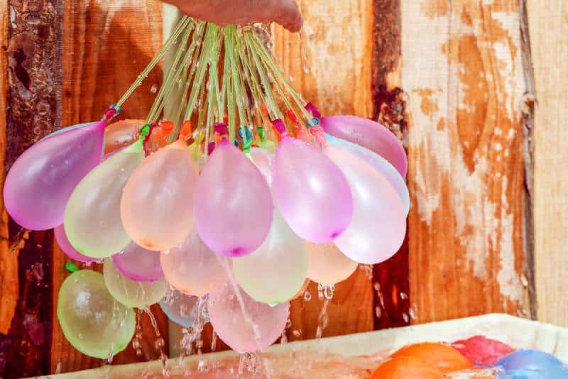 Filling colorful water balloons with water