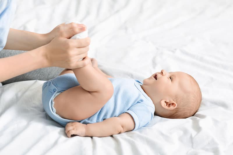 mother doing bowl movement gymnastic with her baby