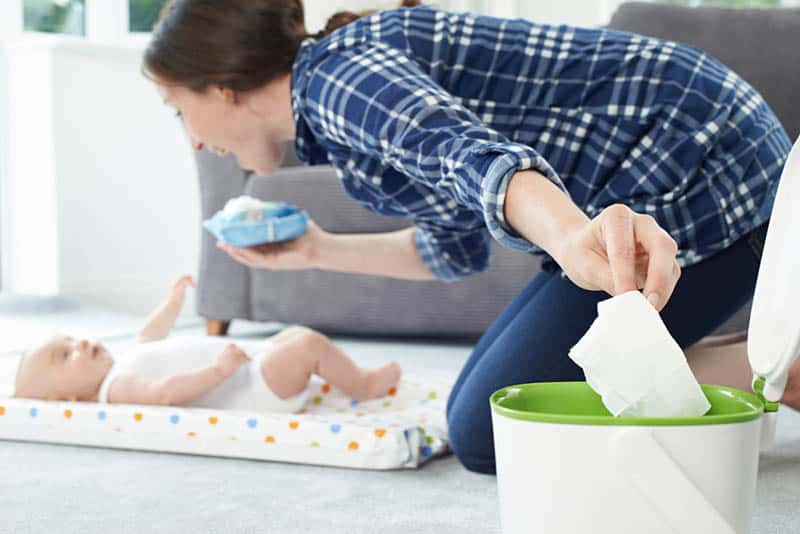  happy mother intrattenere il bambino e la memorizzazione di pulire nel bidone