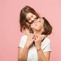 cute little girl hugging her smiling mother