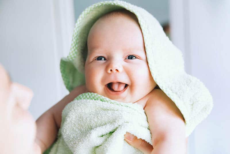 carino bambino sorridente che indossa asciugamano dopo il bagno