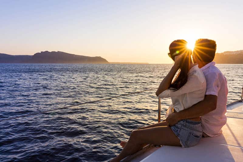 romantic couple sitting on yacht in sunset
