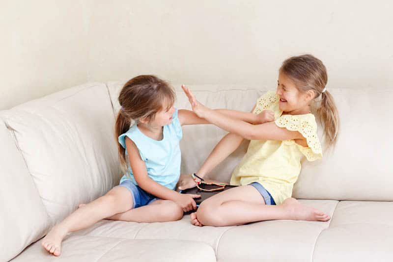 sisters having fight on the couch at home