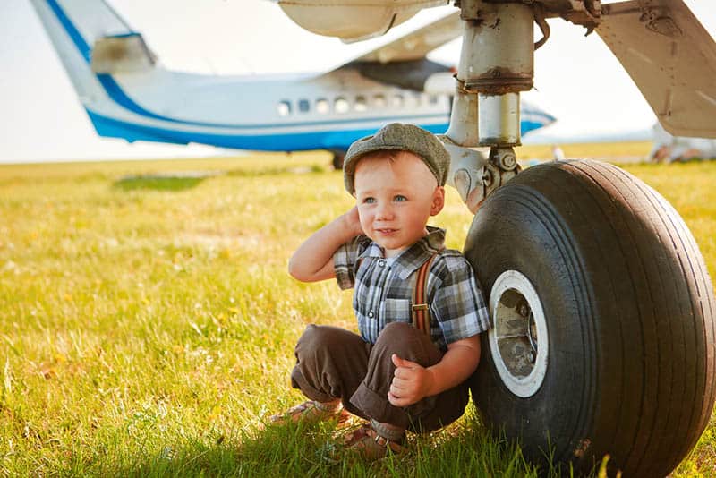 adorable little boy sitting near the aeroplane