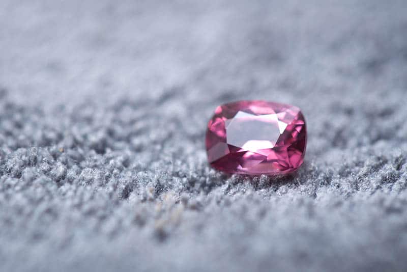 pink spinel gemstone on the grey carpet