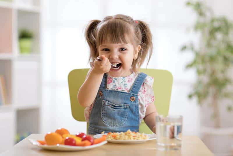 smiling little girl eating lunch