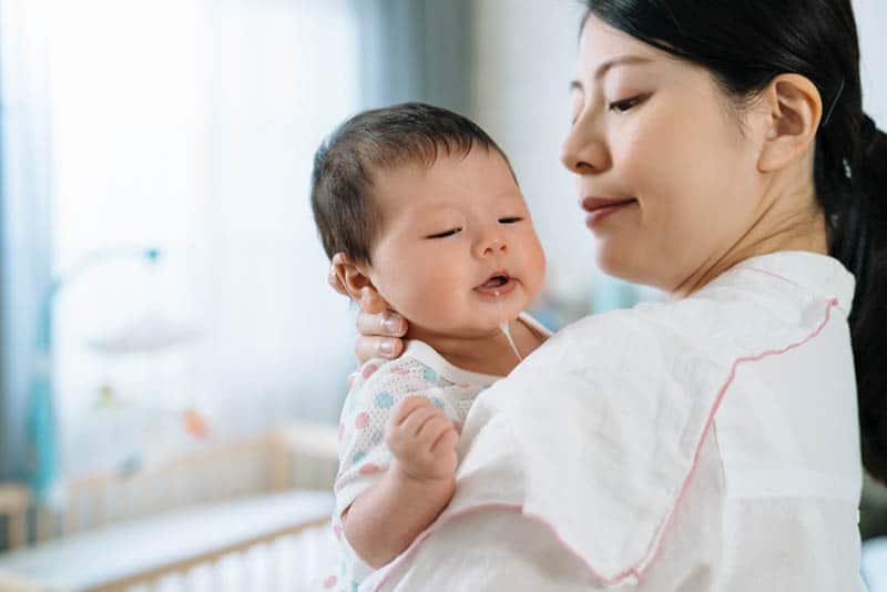 young mother burping her baby