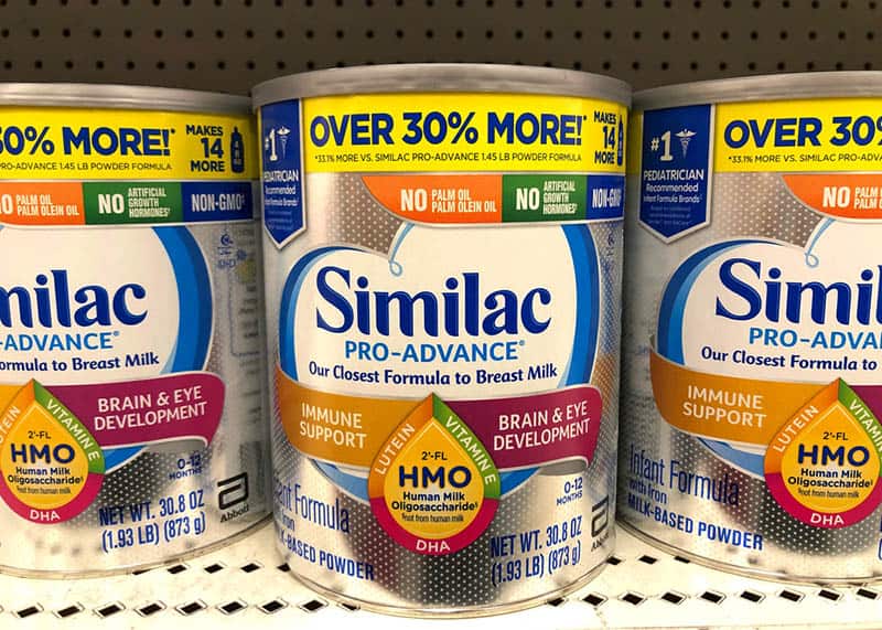 Grocery store shelf with canisters of Similac brand infant formula