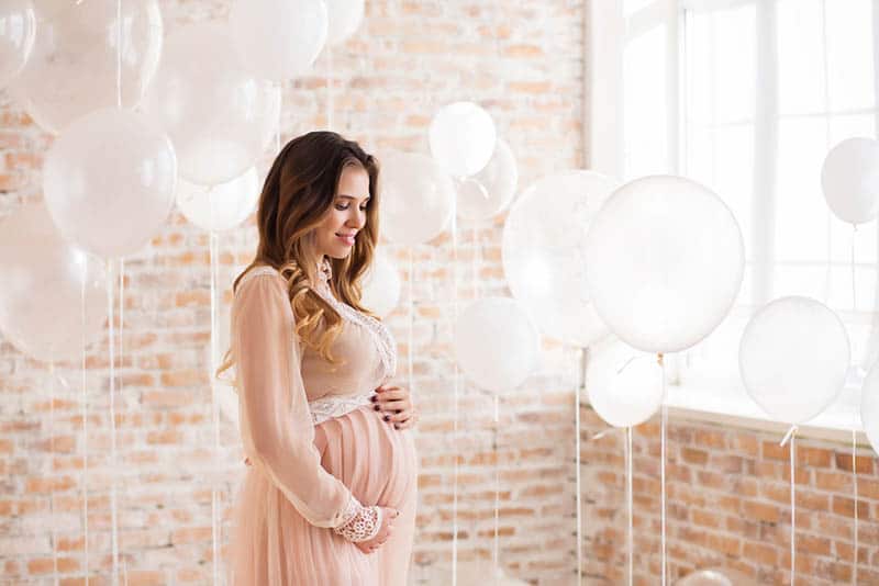 beautiful pregnant woman with balloons in vintage dress