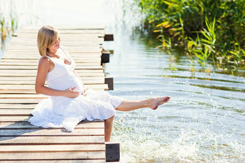 pregnant woman resting on the lake