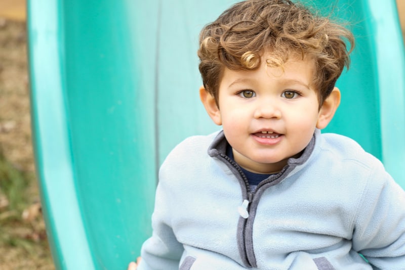 Cute little boy on the slide at the park