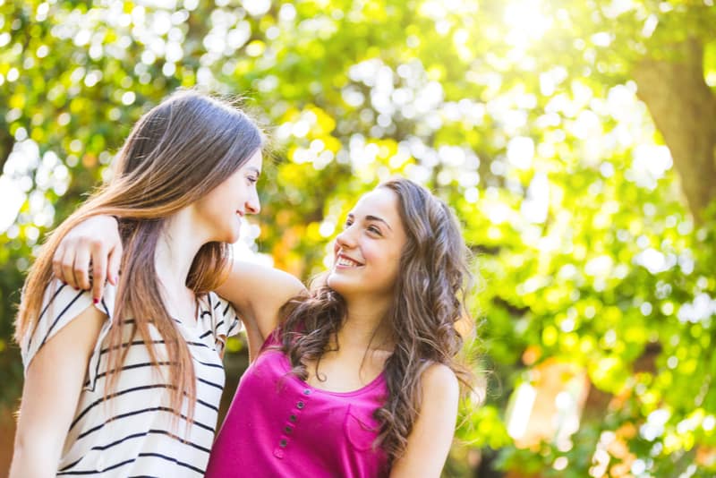 Dos chicas abrazadas juntas en el parque