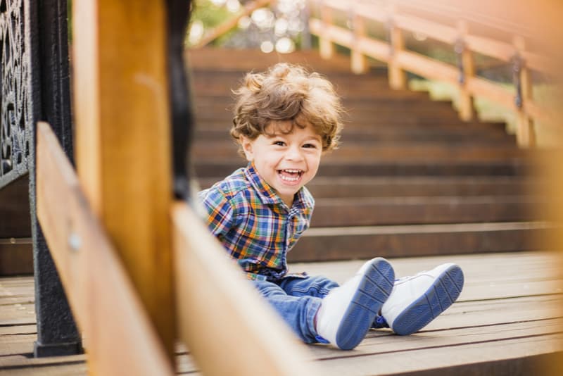  toddler boy sitting and laughing joyfully