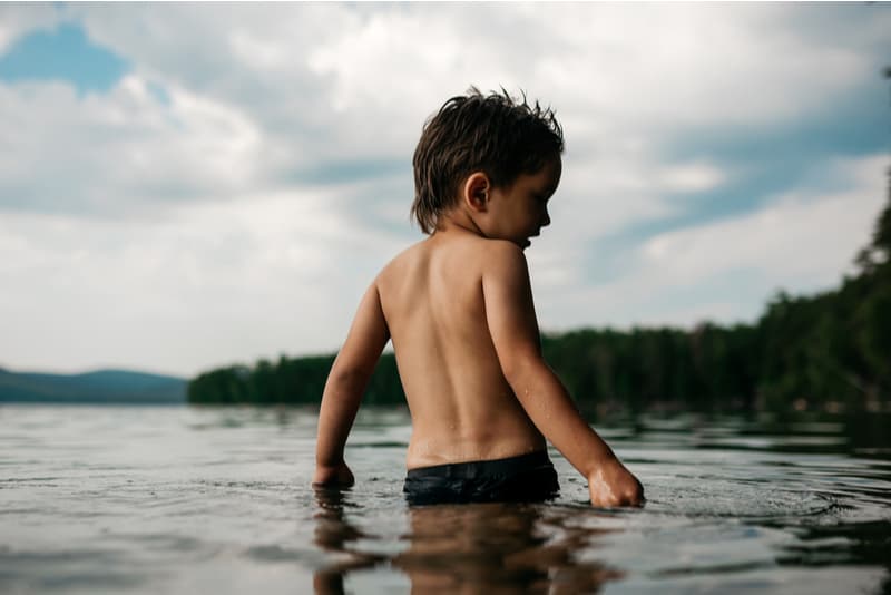 little boy standing in water