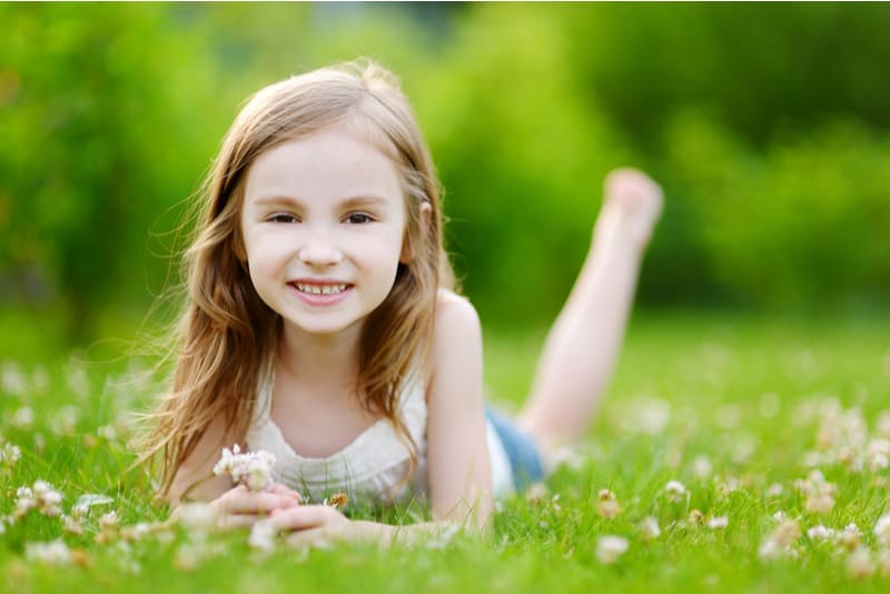 Cute little girl laying on the grass