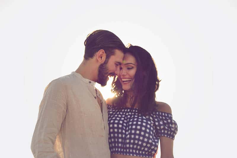 smiling couple standing outdoor together in hug