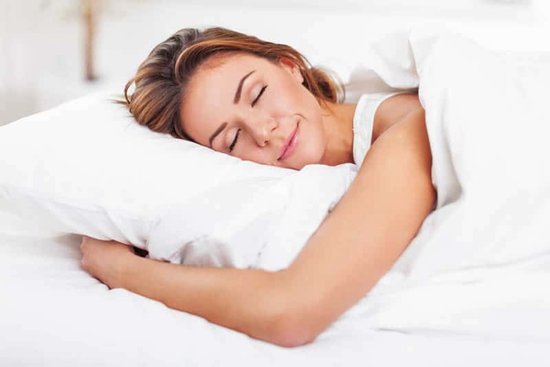  hermosa mujer feliz durmiendo en la cama