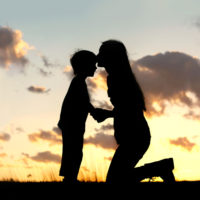 silhouette of a mother kissing her child