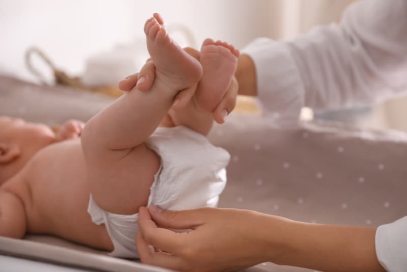 mother changes baby's diaper