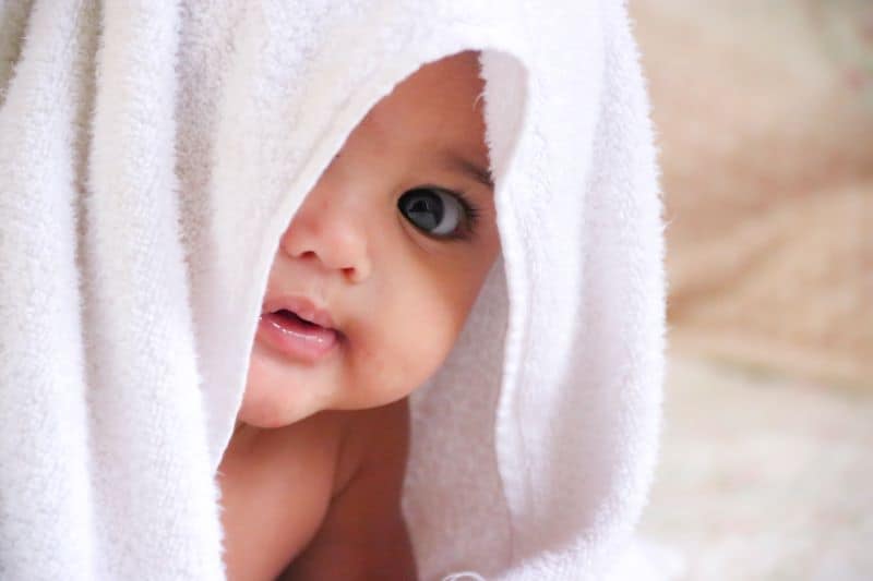 brown-eyed baby with a towel on head