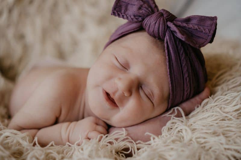 cute baby sleeping while wearing a bow